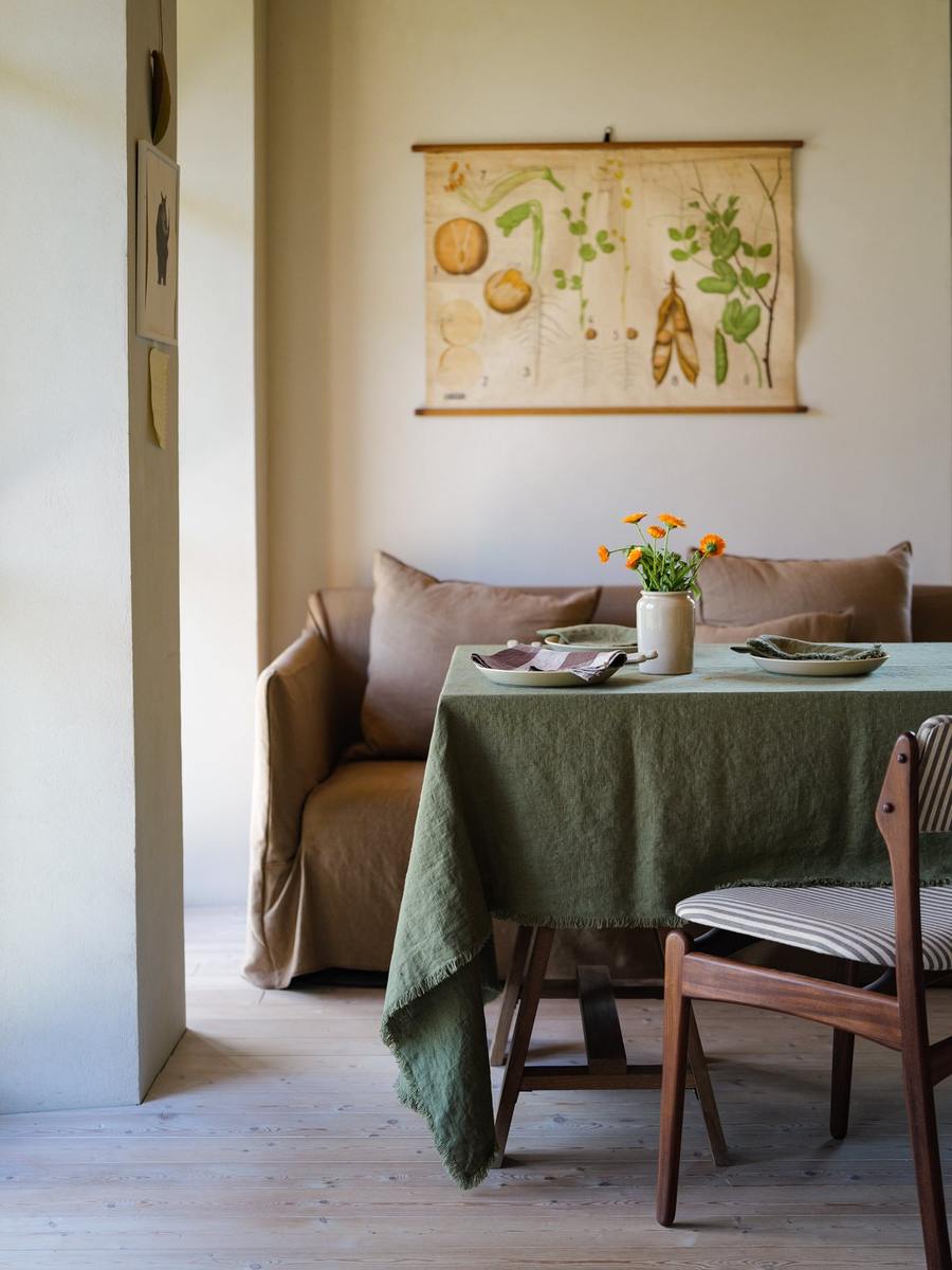 Nappe Olive Green Terra Fringe avec assiettes crème et fleurs orange