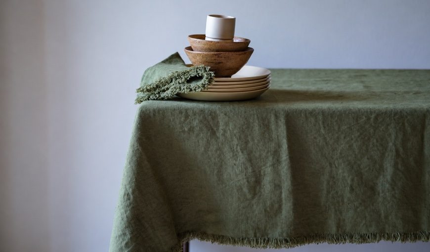 Nappe et serviette en lin Olive Green Terra Fringe avec assiettes crème et bols en bois