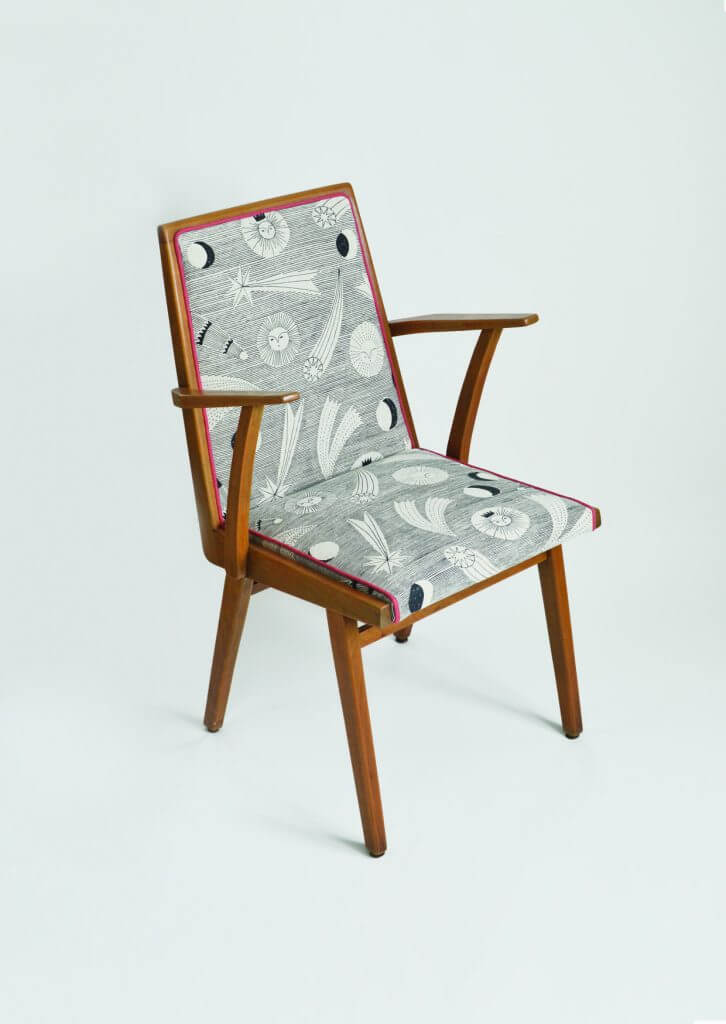 Chaise en bois recouverte d’un tissu sombre à motif céleste