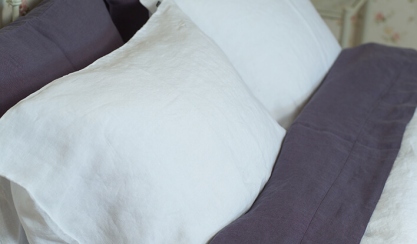 Linge de lit en lin lavé dans des tons clairs sur un lit