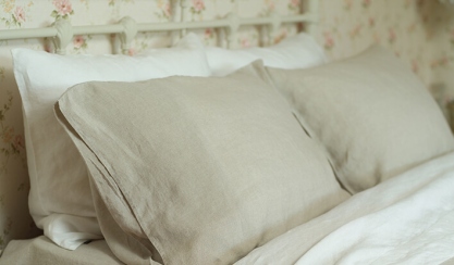 Linge de lit en lin lavé blanc et naturel sur un lit