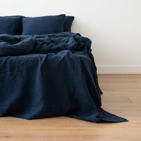 Linge de lit en lin lavé bleu marine sur un lit