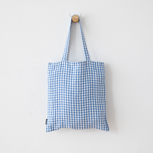 Sac cabas en lin à carreaux vichy bleus suspendu de face à un crochet mural